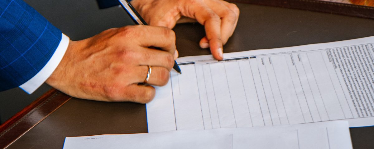 Hand holds pen to sign engagement letter