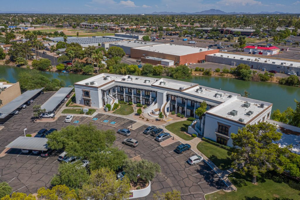 Drone photo of Dobson Professional Plaza, a white office building next to a lake