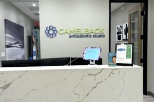 Reception desk with wall sign that reads Camelback Orthodontic Studio