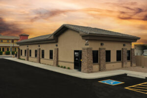 Exterior photo of brown dental office at sunset