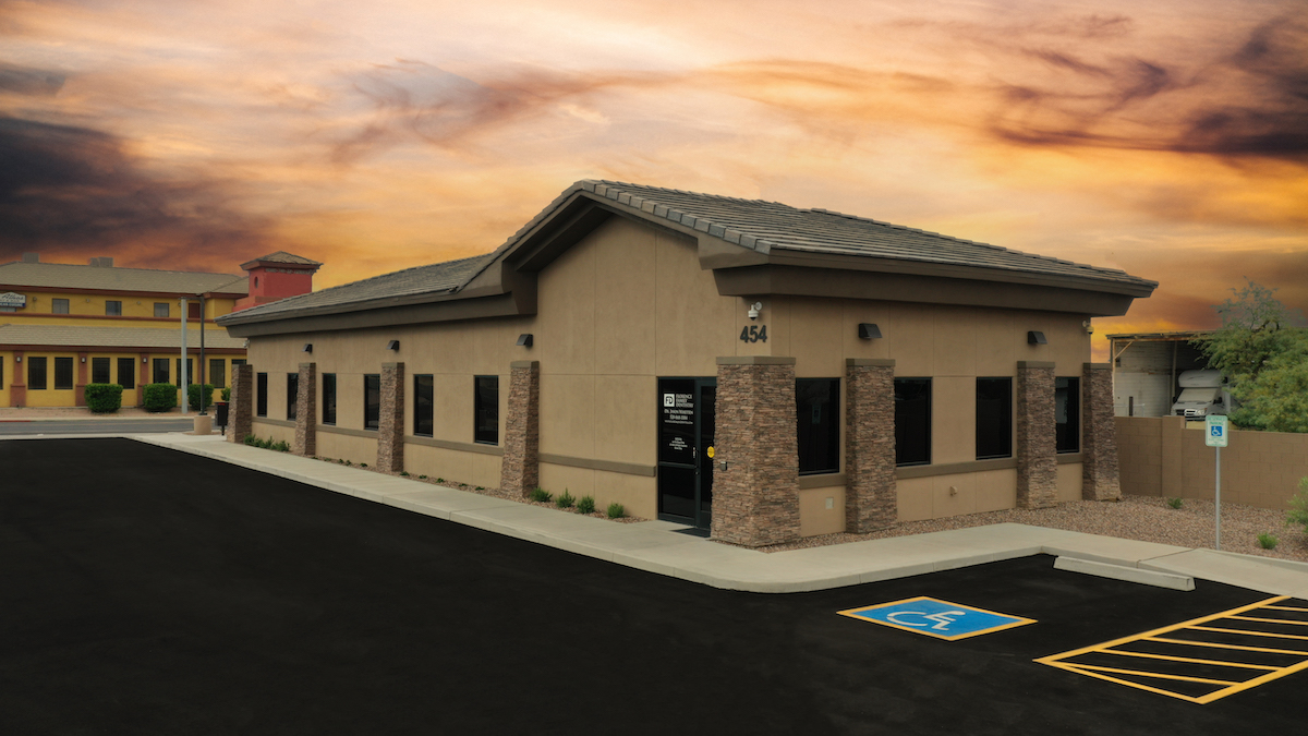 Exterior photo of brown dental office at sunset