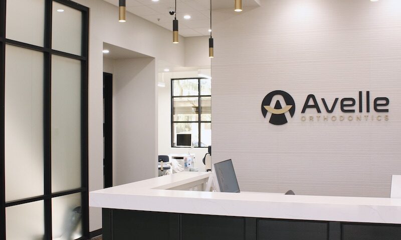 Black desk with writing on the wall that reads Avelle Orthodontics