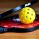 Two pickleball paddles and one pickleball